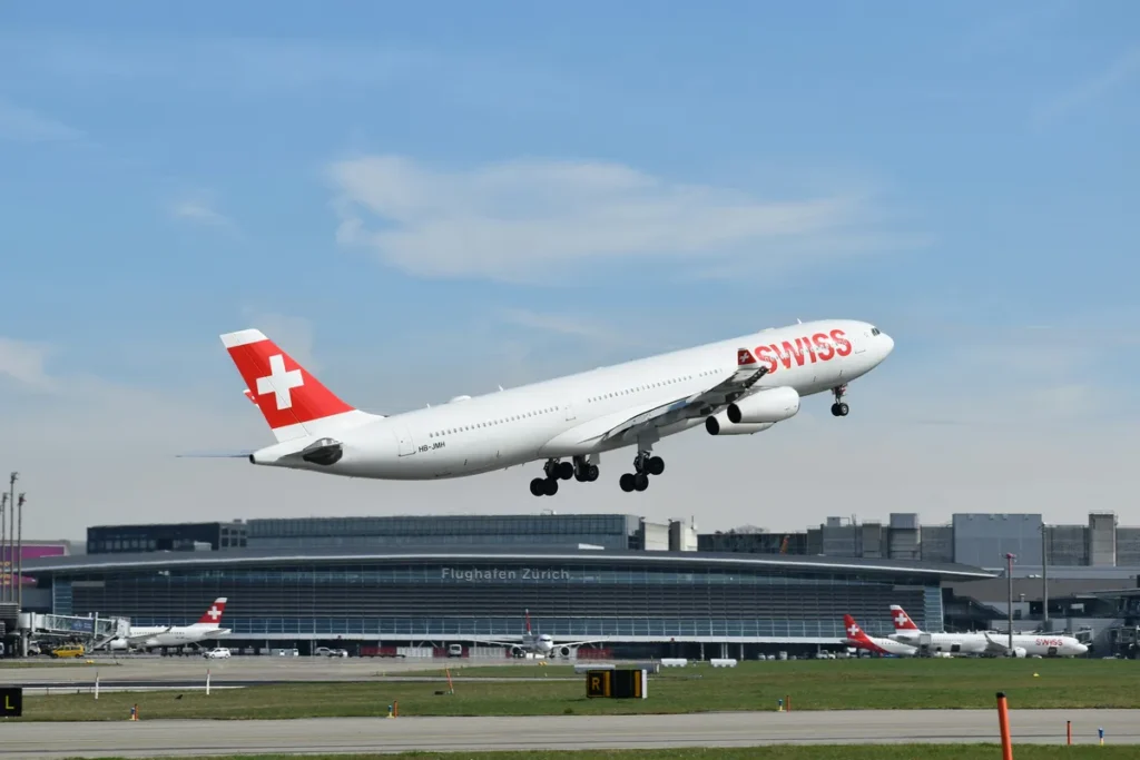 A Swiss aircraft taking off against the backdrop of Zurich Airport. The image serves as a symbol for a running route around Zurich Airport.